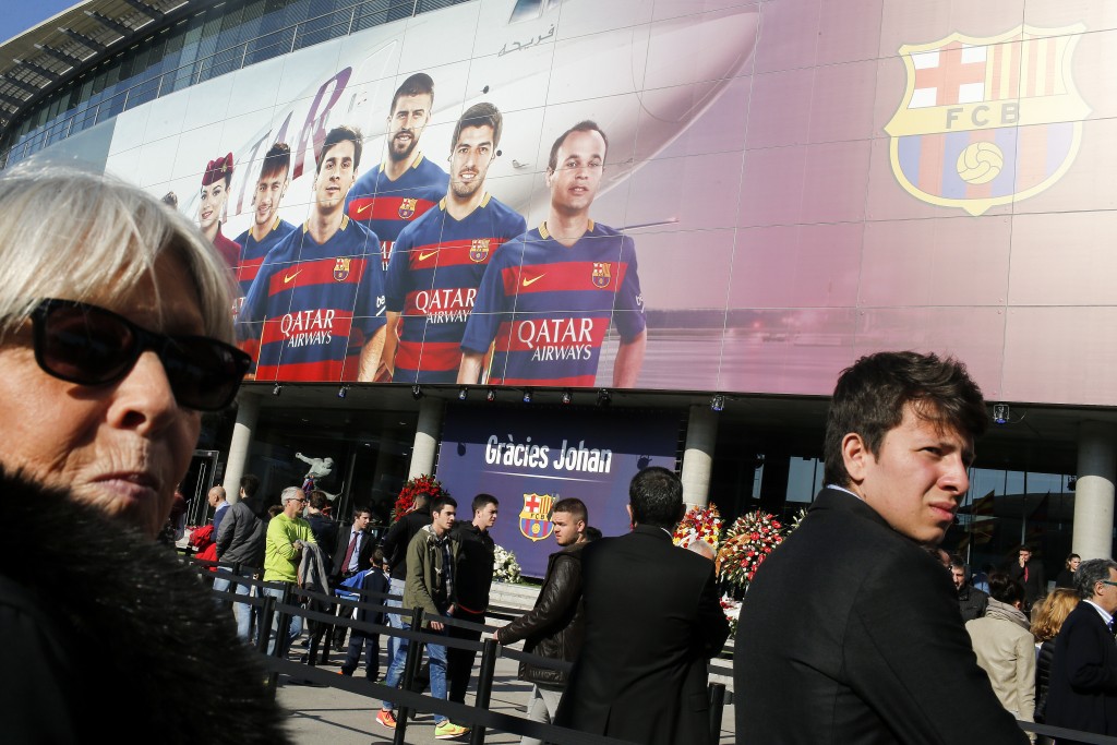 Football fans gather to pay tribute to late Dutch football star Johan Cruyff in a special condolence area set up at Camp Nou stadium, in Barcelona on March 26, 2016. Cruyff, one of the greatest footballers of all time who dazzled with his artistry, died on March 24, 2016 at the age of 68 after losing a battle with lung cancer, prompting an avalanche of tributes from around the sports world. / AFP / PAU BARRENA
