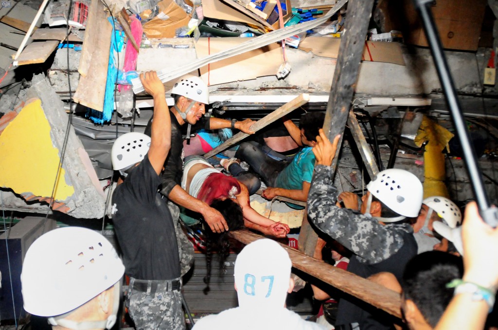 Rescue workers work to pull out survivors trapped in a collapsed building after a huge earthquake struck, in the city of Manta early on April 17, 2016.  At least 41 people were killed when a powerful 7.8-magnitude earthquake struck Ecuador, destroying buildings and sending terrified residents dashing from their homes, authorities said late on April 16.  / AFP PHOTO / API AND AFP PHOTO / Ariel Ochoa