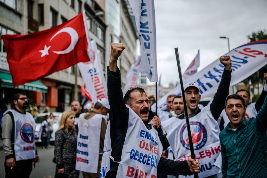 Demonstrators shout slogans and hold up their fists during a May Day rally in Sisli, a district of Istanbul, on May 1, 2016. Turkish labour activists and leftists marked the annual May Day holiday, with thousands of security deployed and bracing for trouble after the authorities refused to allow protests in central Taksim Square. / AFP PHOTO / OZAN KOSE
