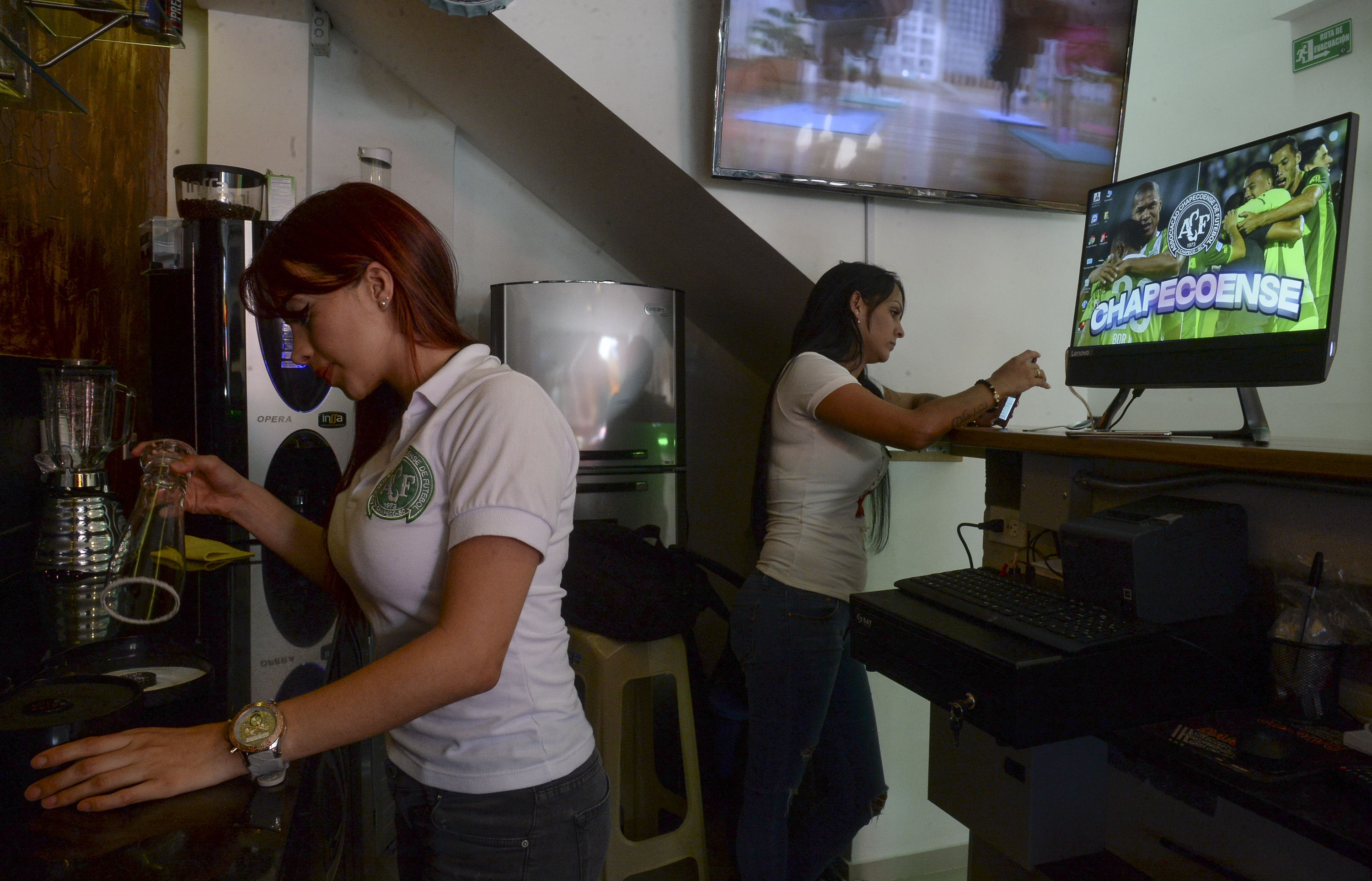 Women work at the new Chapecoense Coffee Bar in Medellin, Colombia on February 16, 2017. The Coffee Bar opened two weeks ago in tribute to the Chapecoense football team from Brazil who perished in Colombia in a plane crash on November 28, 2016. / AFP PHOTO / RAUL ARBOLEDA