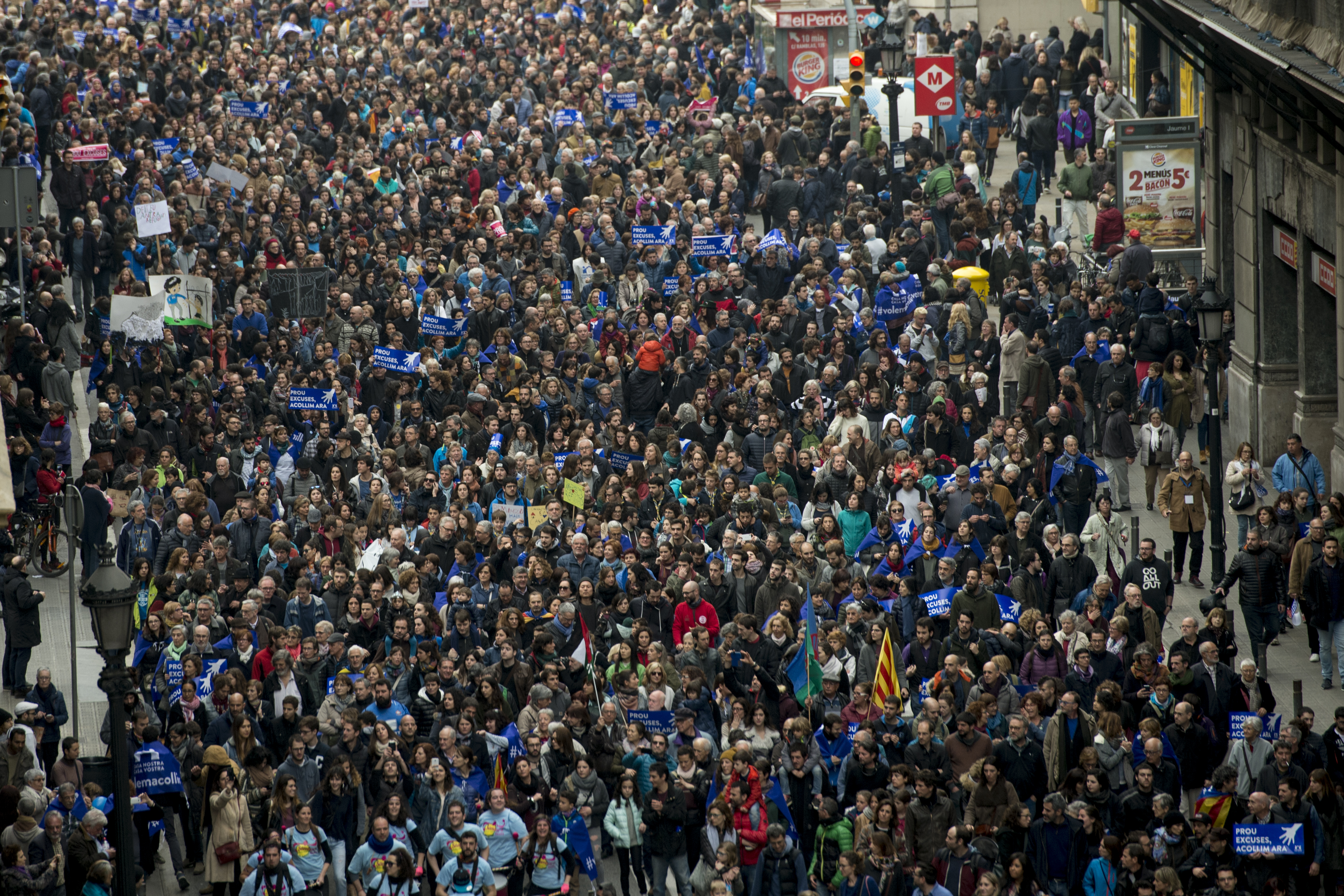 Some of thousands of people walk as they demonstrate to demand to welcome refugees in Barcelona on February 18, 2017.  Some 160,000 people participated today in a demonstration in Barcelona to demand that Spain welcomes "right now" thousands of refugees as it had committed itself in 2015. / AFP PHOTO / Josep Lago