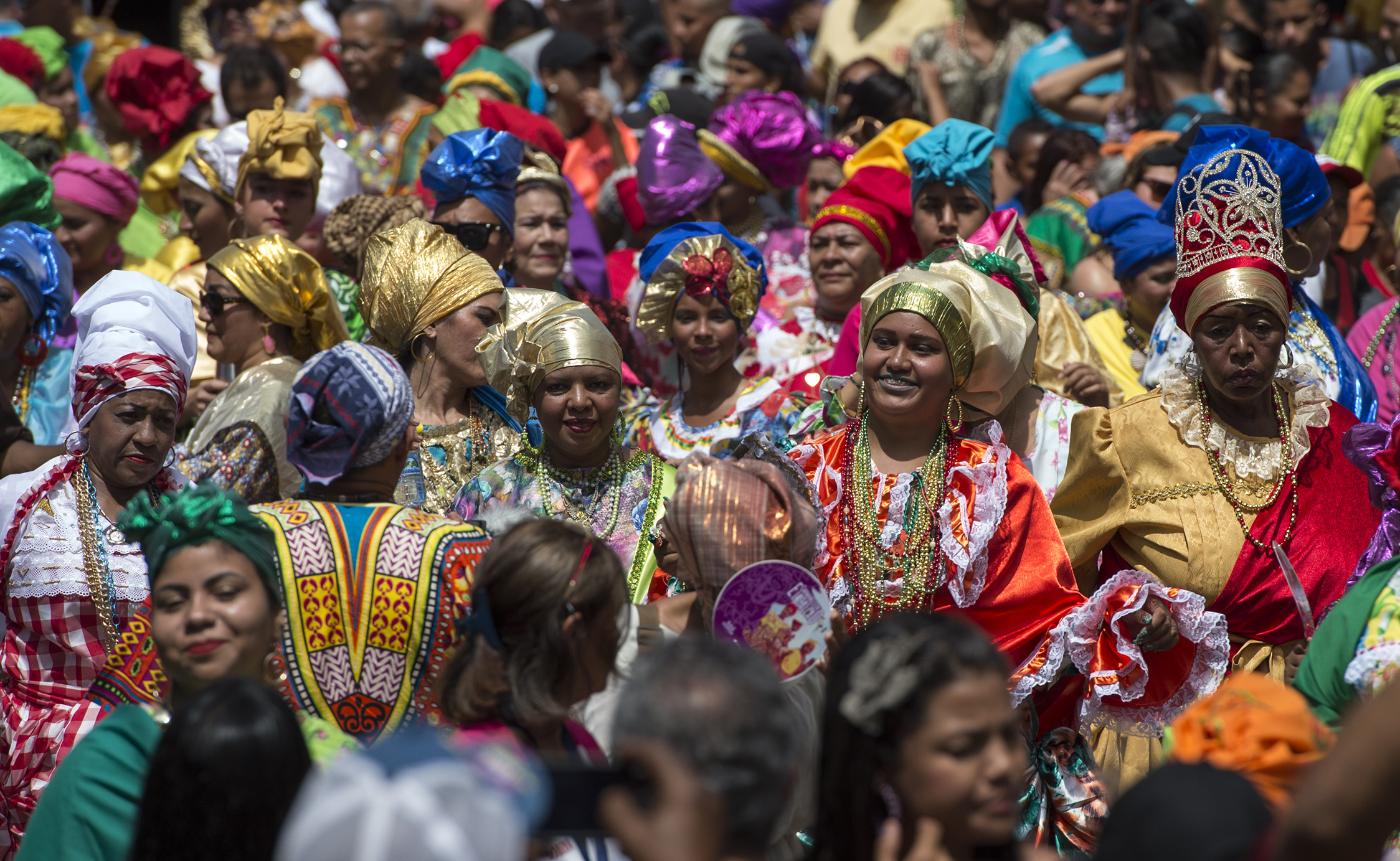Women dressed as "madamas" dance as they take part in a parade during the Carnival in El Callao, Bolivar state, Venezuela on February 26, 2017.  El Callao's carnival was recently named Unesco's Intangible Cultural Heritage of Humanity and is led by the madamas, the pillars of Callaoense identity representing Antillean matrons considered the communicators of values, who dance and wear colourful dresses. / AFP PHOTO / JUAN BARRETO
