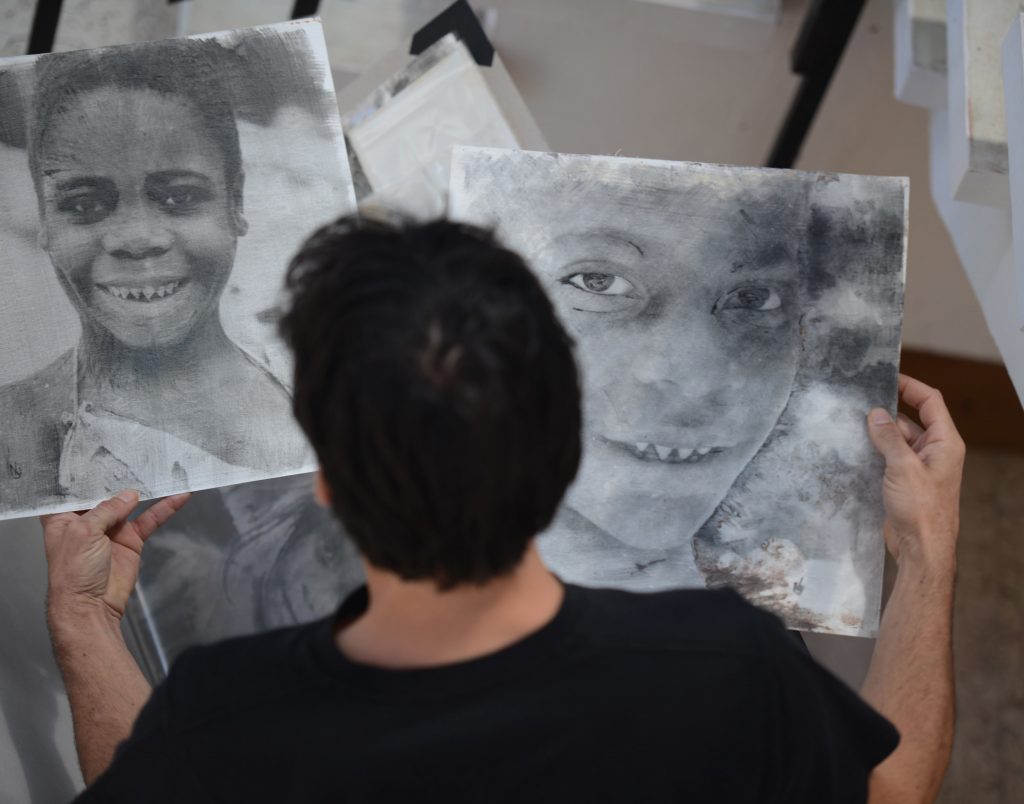 French photographer Nicolas Guyot holds some of his works during his exhibition 'Imagenes de lo insondable" (Images of the unfathomable) in Tegucigalpa on March 21, 2017.   Guyot's work includes images taken in Syria, Congo and Nepal, among other scenarios, processed using film techniques and silver bromide development. / AFP PHOTO / ORLANDO SIERRA